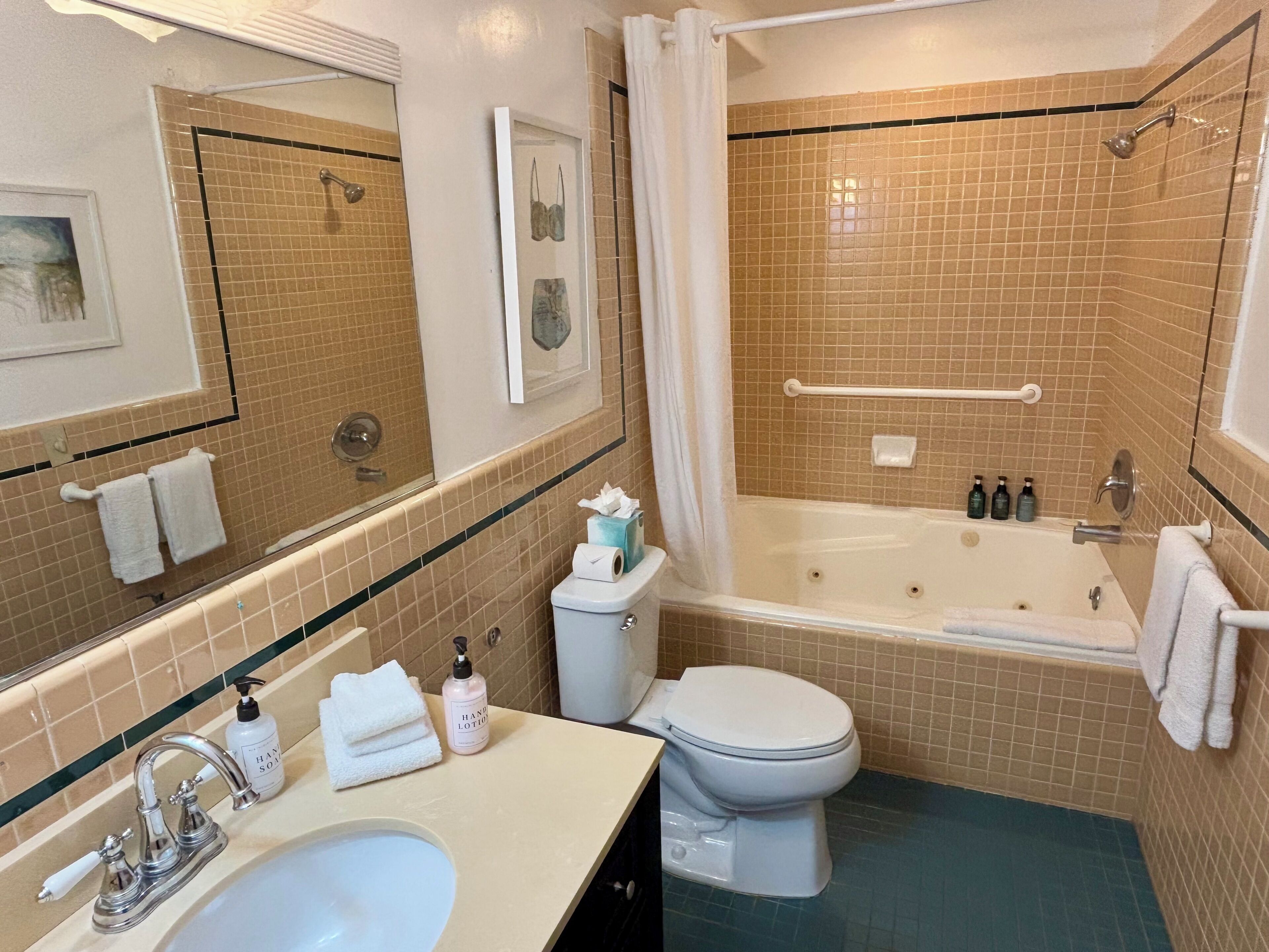 A bathroom with a bathtub, toilet, sink, and a shower area with a glass door.