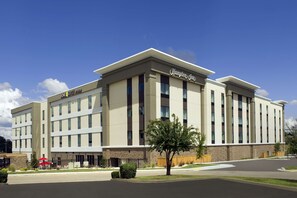 Edifici modern d'hotel amb terrat pla i un rètol que diu "Hampton Inn".