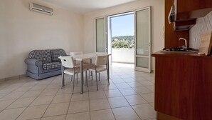 A compact living space with a dining area, a kitchenette, and a sofa. - Casa del Sole Trilo A (Castrignano del Capo)