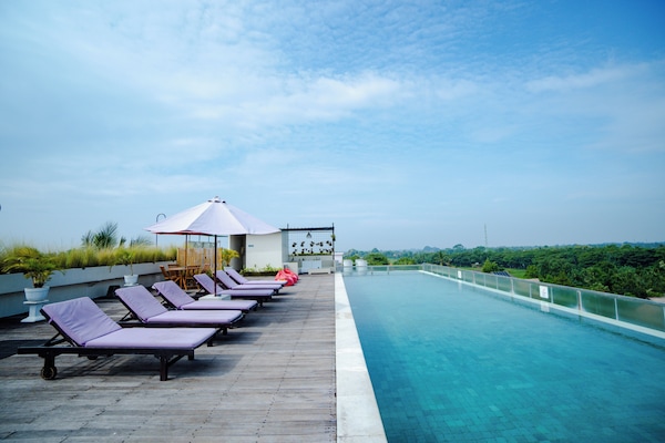 Una piscina al aire libre, sillones reclinables de piscina