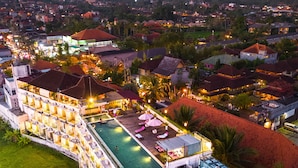 A hotel with a swimming pool, multiple floors, and a view of the surrounding town and mountains. - The Evitel Resort Ubud (Ubud)