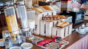 A buffet setup with various food items and utensils. - The Evitel Resort Ubud (Ubud)