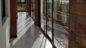 Un pasillo con ventanas amplias, suelo de baldosas y paredes de ladrillo.