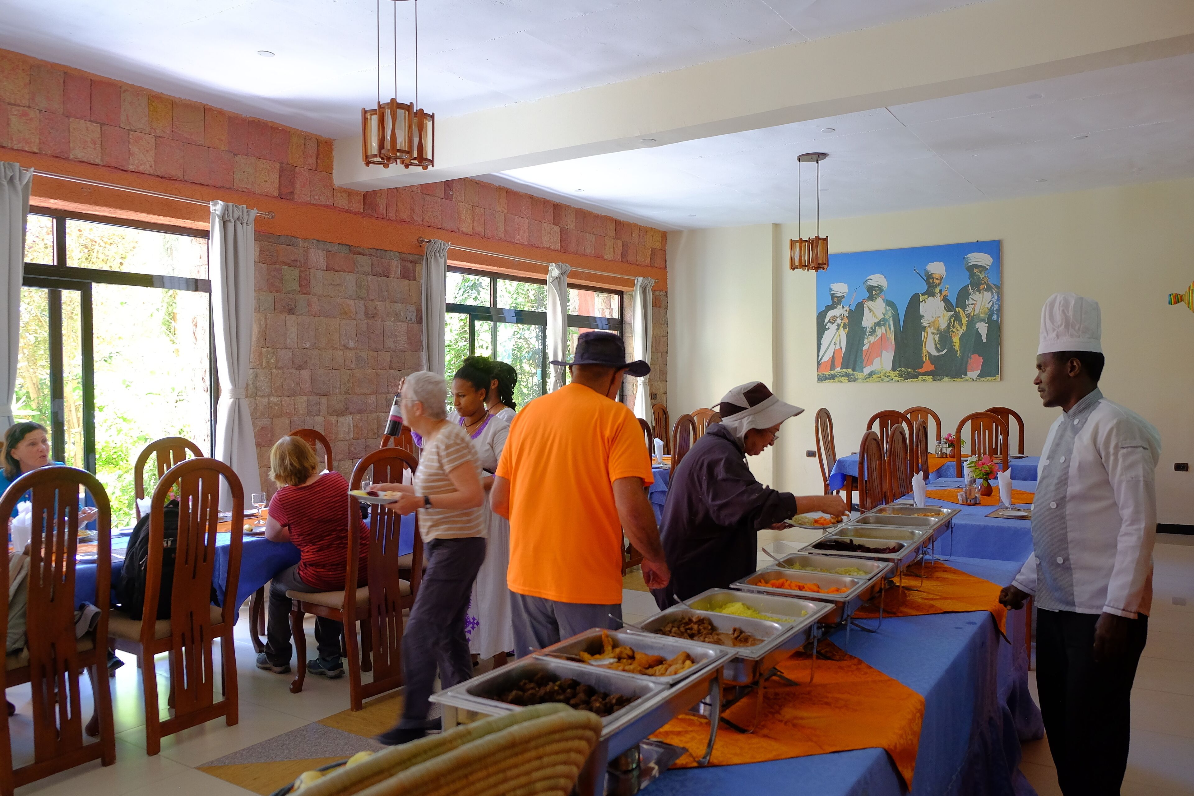A buffet setup with multiple food stations and attendees.