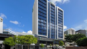 Een meerlaags Holiday Inn Express hotel met een moderne glazen gevel, gelegen in een stedelijke omgeving met heldere luchten.