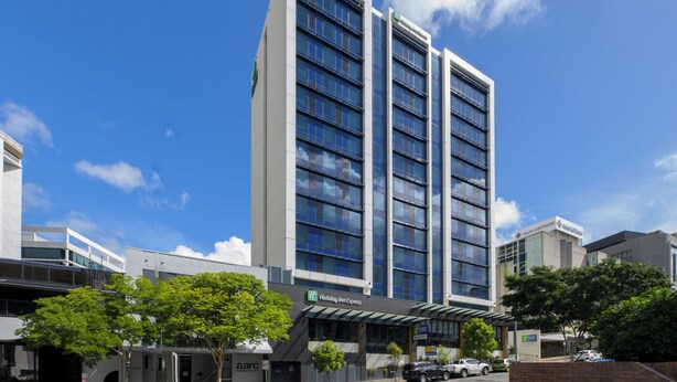 A multi-story Holiday Inn Express hotel with a modern glass facade, located in an urban setting with clear skies. - Holiday Inn Express Brisbane Central by IHG (Spring Hill)