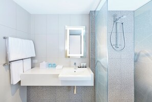A modern bathroom with a white sink, mirror, and shower. - Holiday Inn Express Brisbane Central by IHG (Spring Hill)
