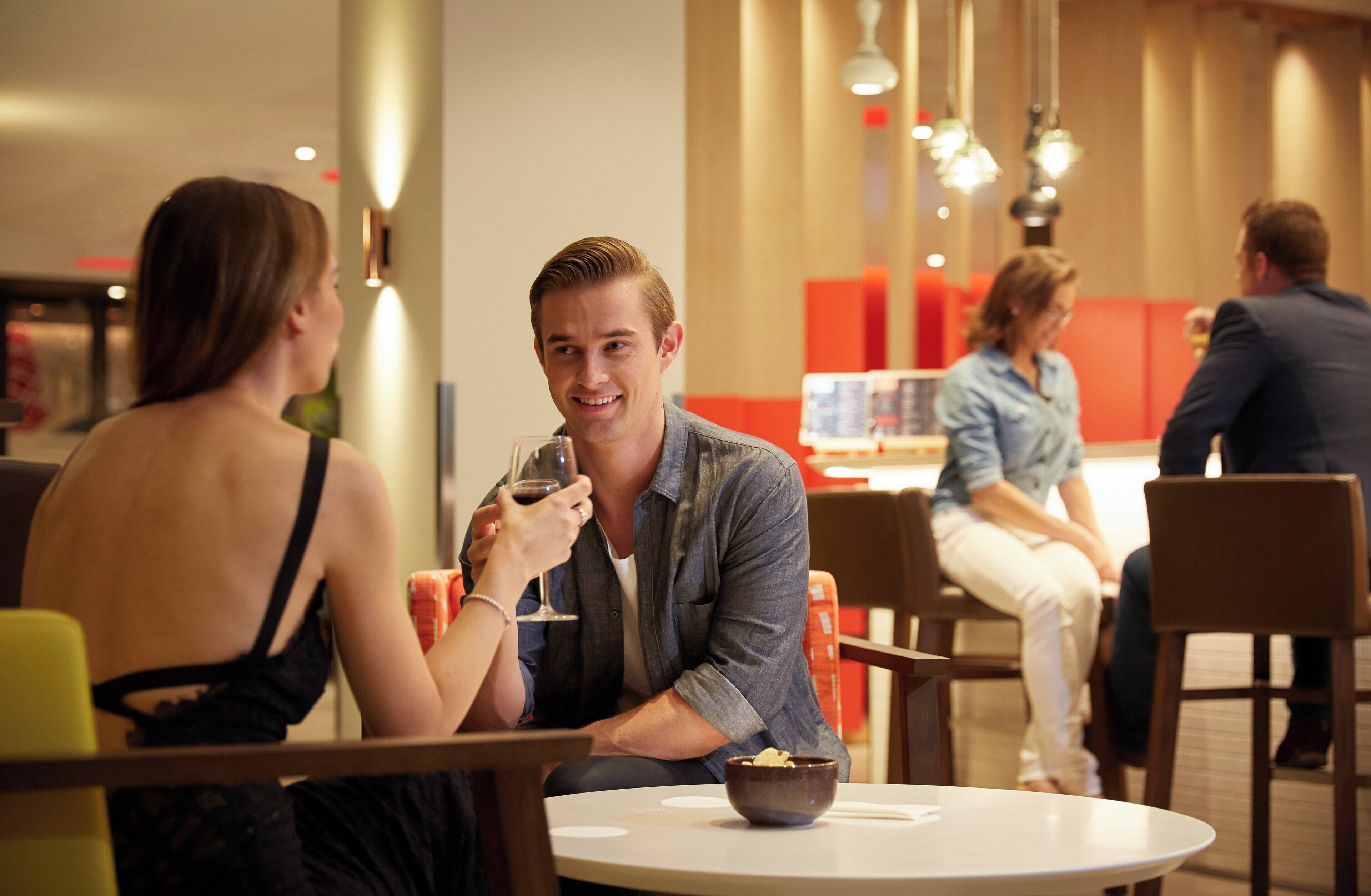 A dining area with round tables, chairs, and a bowl of food on one table.