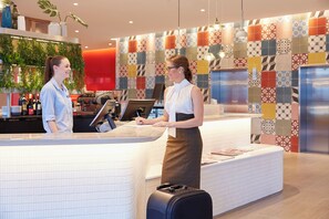 Un comptoir d’accueil au design moderne, doté d’un écran numérique et d’un comptoir.