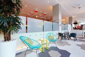 A modern indoor space with seating, a staircase, and a plant. - Holiday Inn Express Brisbane Central by IHG (Spring Hill)