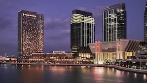 A high-rise hotel with a prominent 'Four Seasons' sign, a waterfront view, and modern architecture. - Four Seasons Hotel Abu Dhabi at Al Maryah Island (Abu Dhabi)