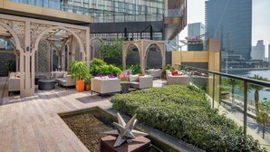 A rooftop terrace with outdoor seating, a decorative star sculpture, and a view of the city skyline. - Four Seasons Hotel Abu Dhabi at Al Maryah Island (Abu Dhabi)