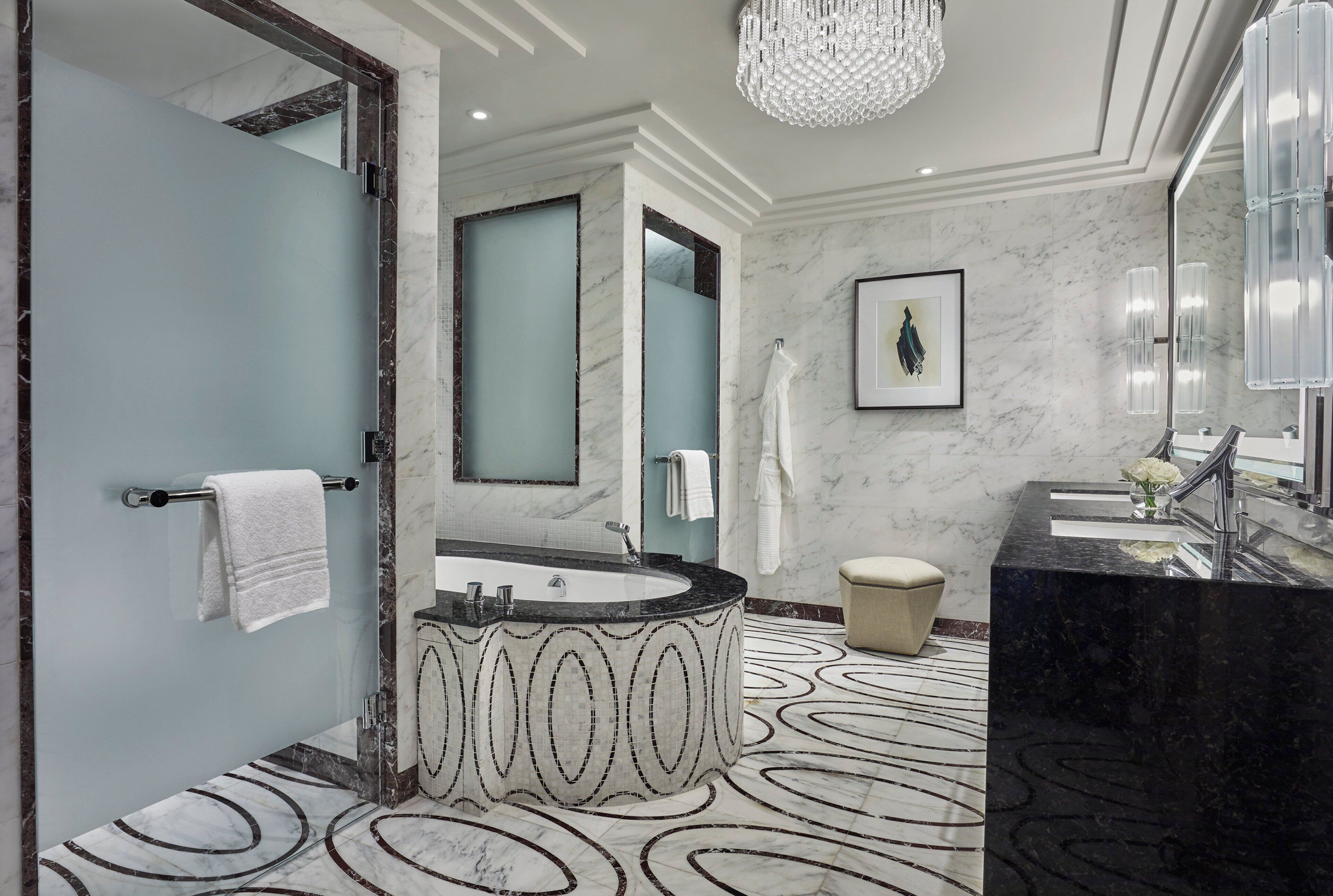Un baño moderno con una bañera amplia, un inodoro independiente y un tocador con espejo.