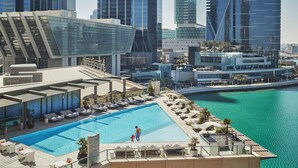 A rooftop pool with lounge chairs and a view of the city skyline. - Four Seasons Hotel Abu Dhabi at Al Maryah Island (Abu Dhabi)