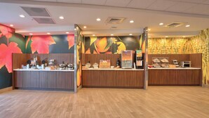 A modern reception area with wooden counters, a fruit display, and a wall mural. - Fairfield Inn & Suites by Marriott Philadelphia Horsham (Willow Grove)