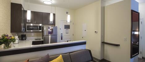 A modern kitchen with stainless steel appliances, a built-in microwave, and pendant lighting.