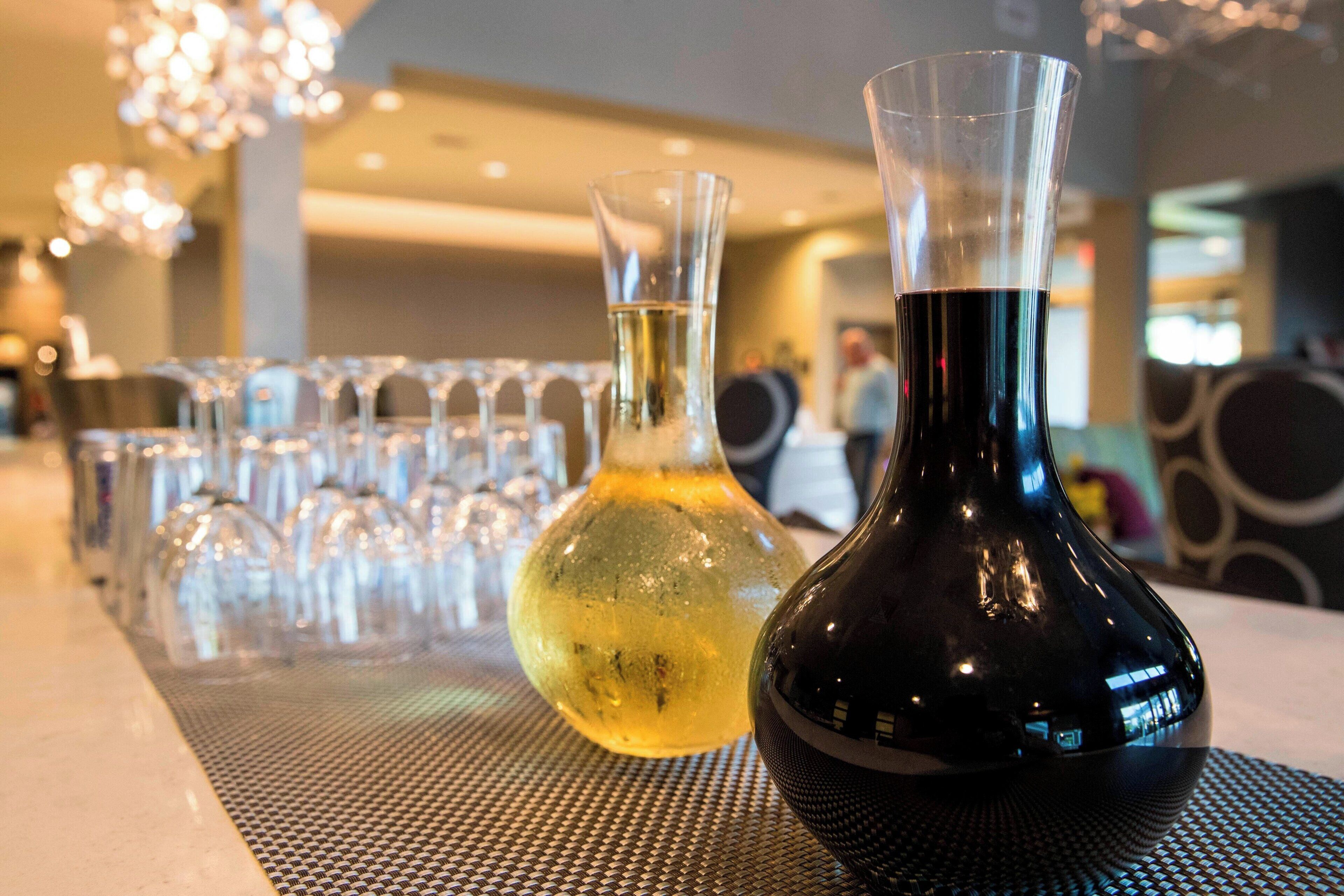 Un coin bar avec un assortiment de verres et deux vases placés sur une table.