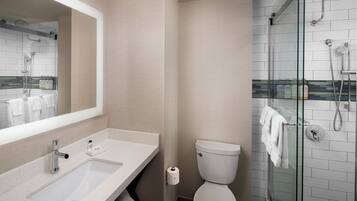 A bathroom with a white sink, mirror, and toilet.
