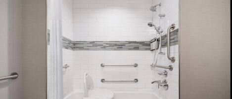 A bathroom with a bathtub, a shower area, and a toilet.