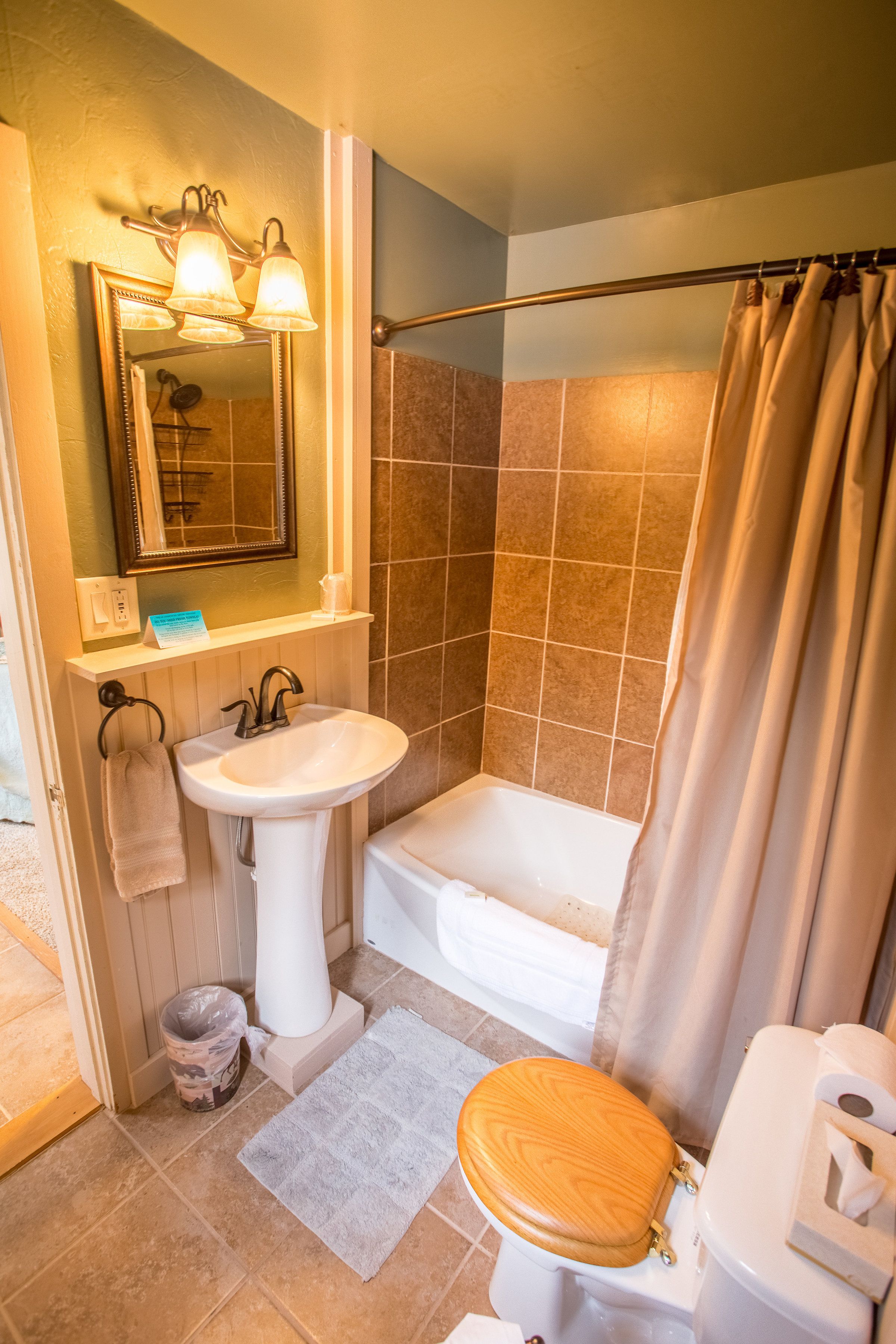 A bathroom with a sink, mirror, and bathtub.