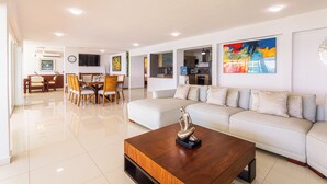 A modern living room with a sofa, coffee table, and dining area.