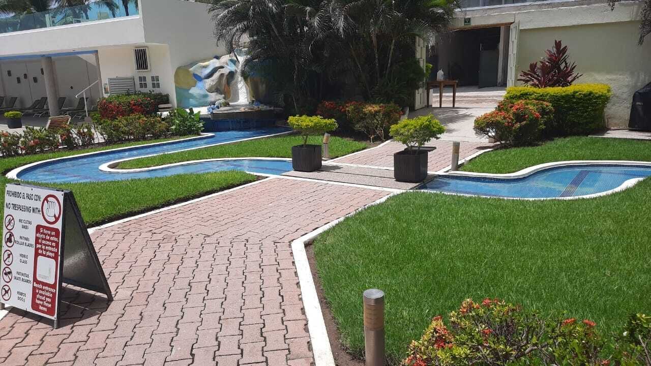 Ein Poolbereich mit mehreren Schwimmbecken, einem gepflasterten Weg und einem Schild mit Betretungsverbot.
