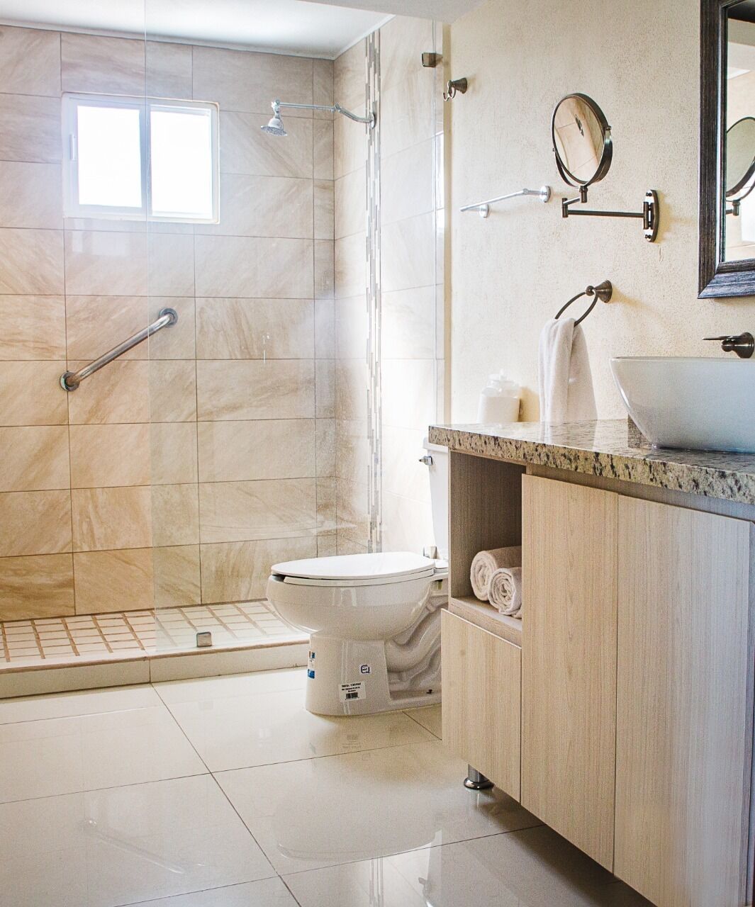 A modern bathroom with a shower, toilet, and vanity.