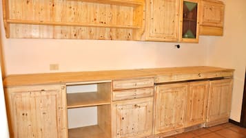 Une cuisine avec des meubles de rangement en bois, un plan de travail et un pare-feu.