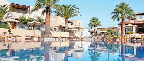 Een buitenzwembad en ligstoelen