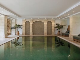 Una piscina al aire libre, sillones reclinables de piscina