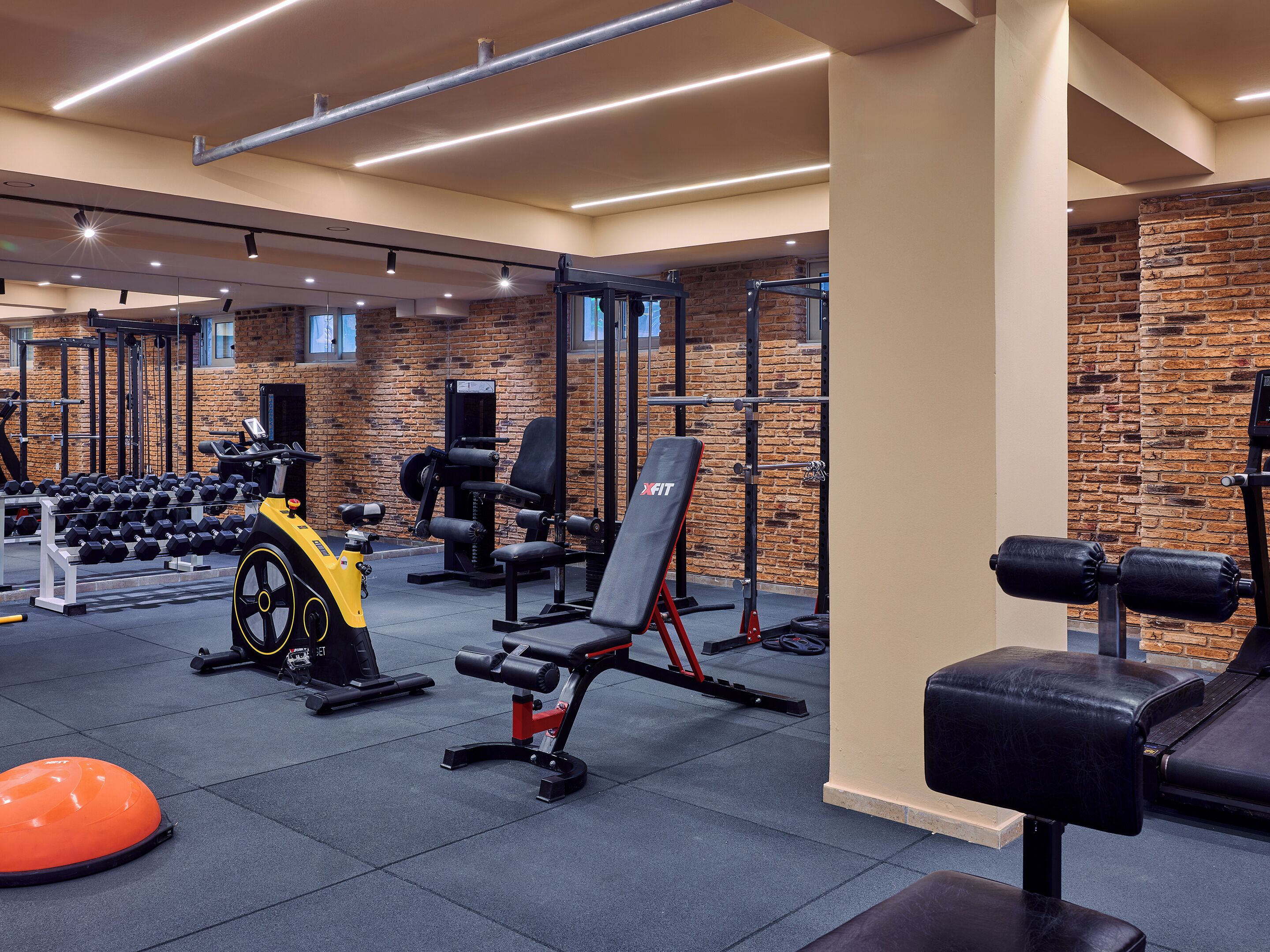 Una sala de gimnàstica amb equips per a aixecar peses, bancs i peses.