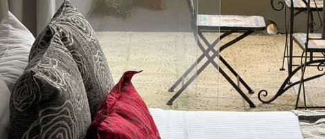 Ein Zimmer mit einer Couch, Kissen, einem Tisch und einem Stuhl.