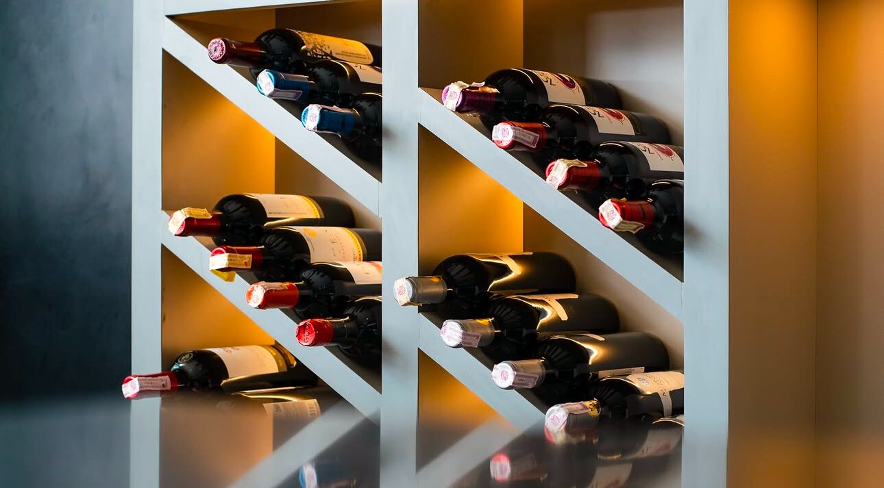 Una botellera con varias botellas de vino.