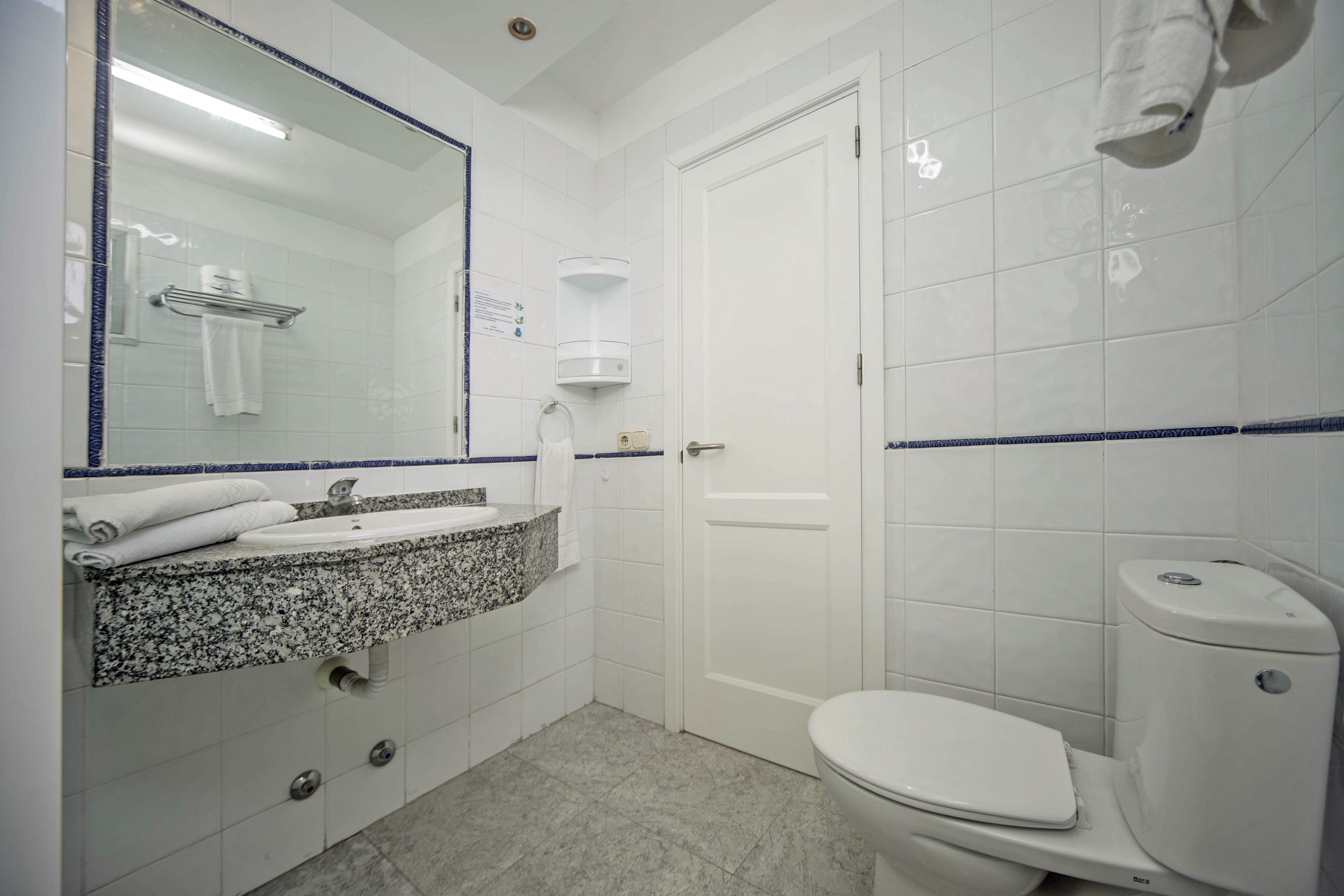 Ein Badezimmer mit Waschbecken, Spiegel und Toilette.