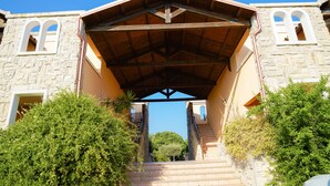 Un edificio in pietra con un portico e una scala che vi conduce.