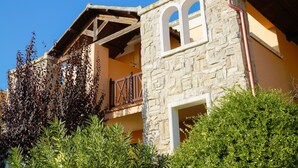 Un edificio in pietra con un balcone e una finestra.