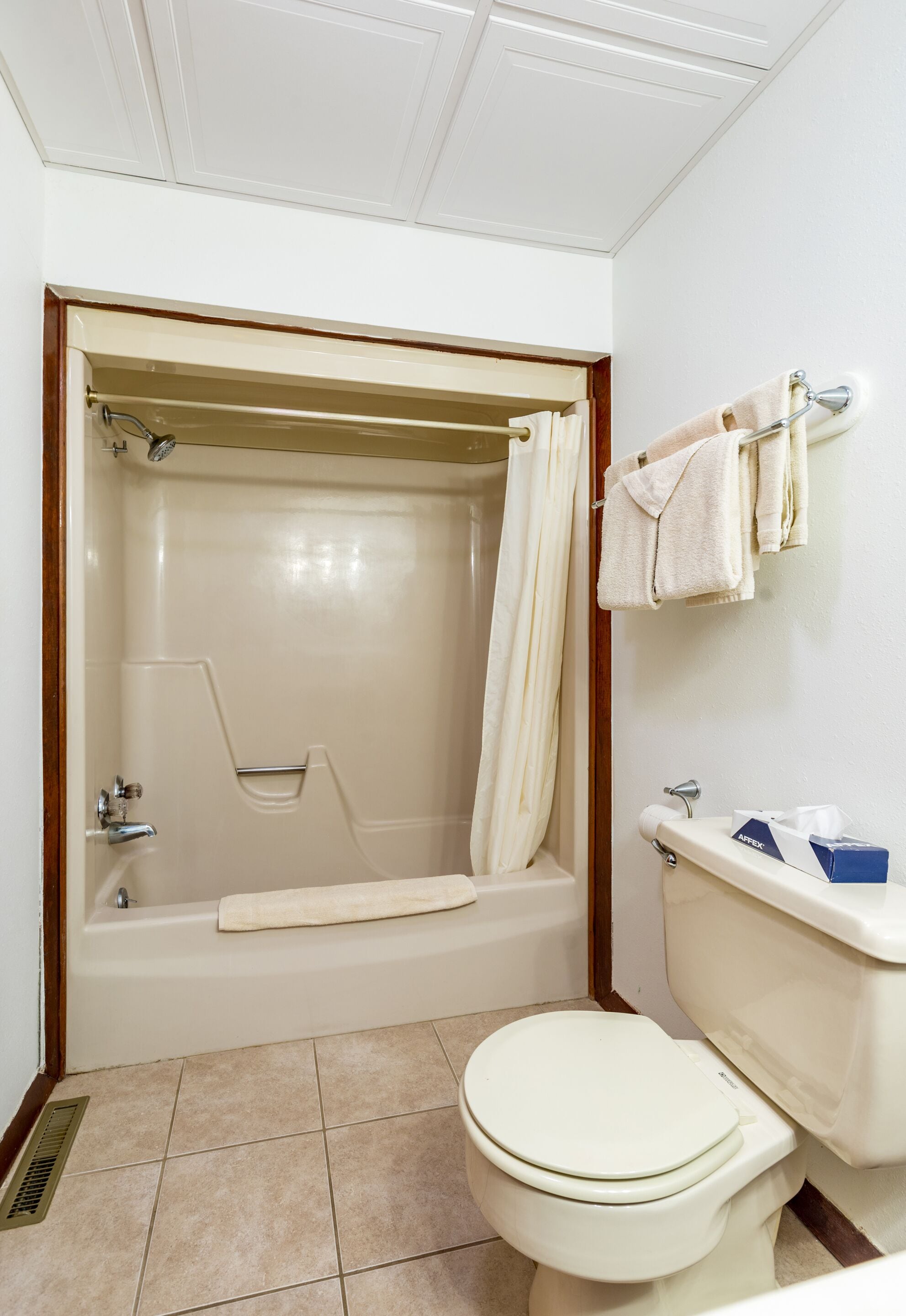 Un baño con bañera, inodoro y perchero para toallas.