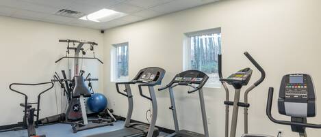 A gym with treadmills, elliptical machines, and a stationary bike.
