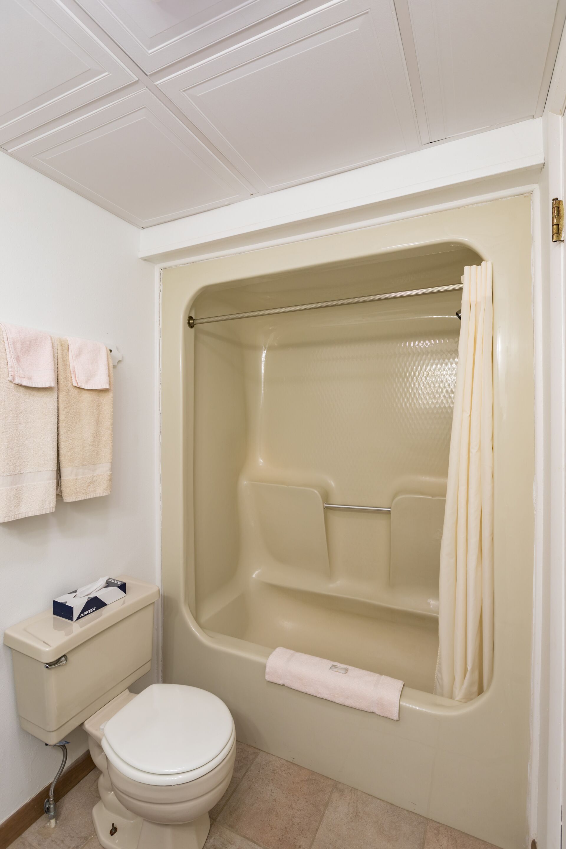 Une salle de bain équipée d’une baignoire, de toilettes et d’un porte-serviettes avec des serviettes.