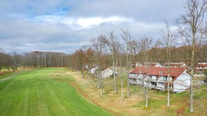 A golf course with a clubhouse, surrounded by trees and houses. - Crown Resorts at Silverwoods (DuBois)