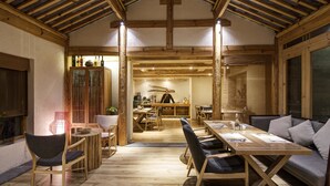 A cozy, rustic dining area with wooden furniture and a high ceiling.