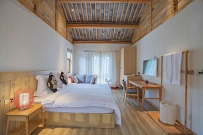 A bedroom with a wooden ceiling, a bed with white bedding, a desk with a chair, a TV, and a window with curtains. - Arro Khampa by Zinc Journey Lijiang (Lijiang)