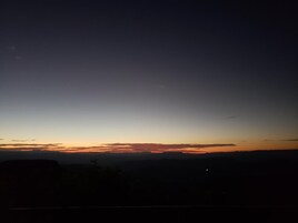 Un paisaje nocturno con cielo despejado y horizonte lejano.