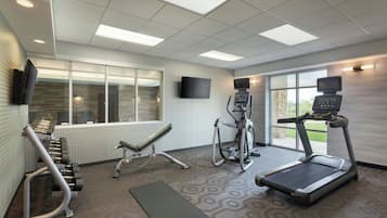 A gym with treadmills, an elliptical, and free weights.