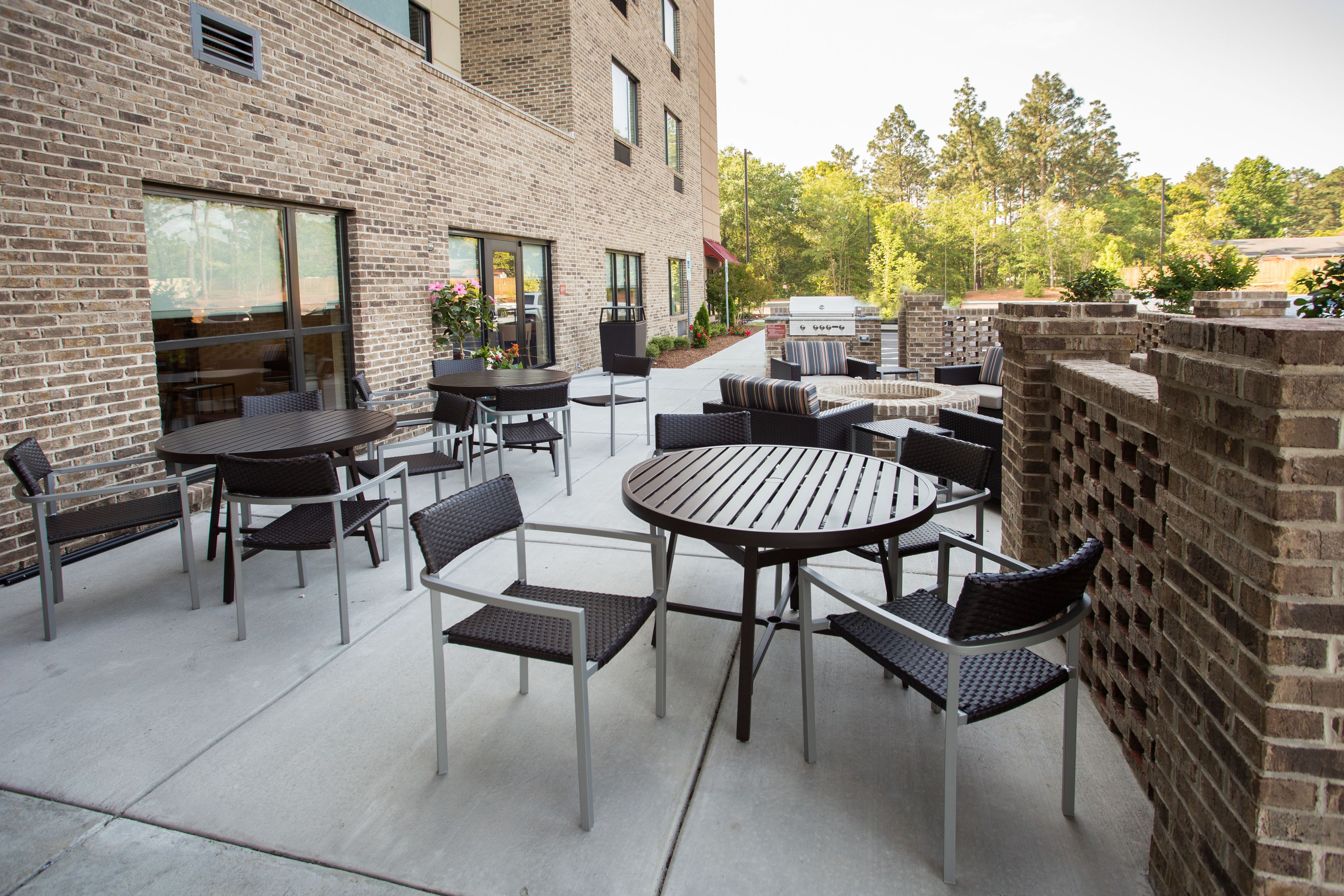 An outdoor patio with brick walls, tables, and chairs.