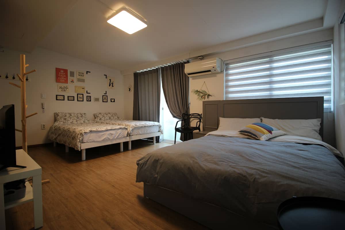 Une chambre avec un lit simple, un petit lit, un bureau et une chaise.