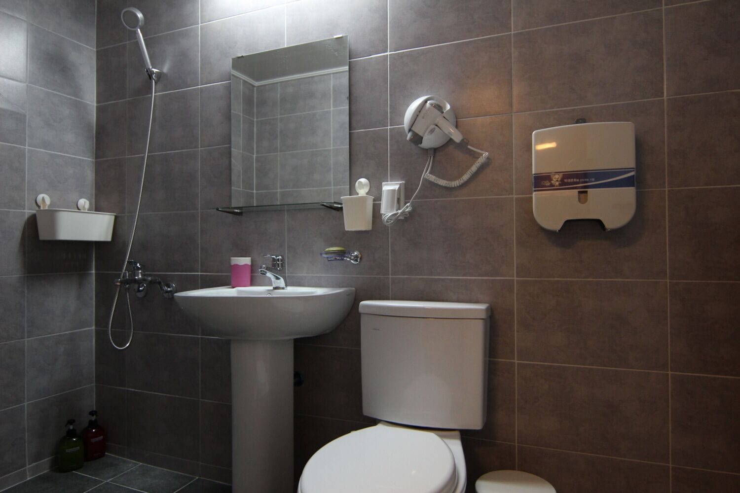 Un bagno moderno con doccia, lavandino, water e specchio.