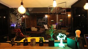 A modern interior with wooden flooring, potted plants, a desk, and a large window. - Bunk Guest House - Hostel (Seoul)