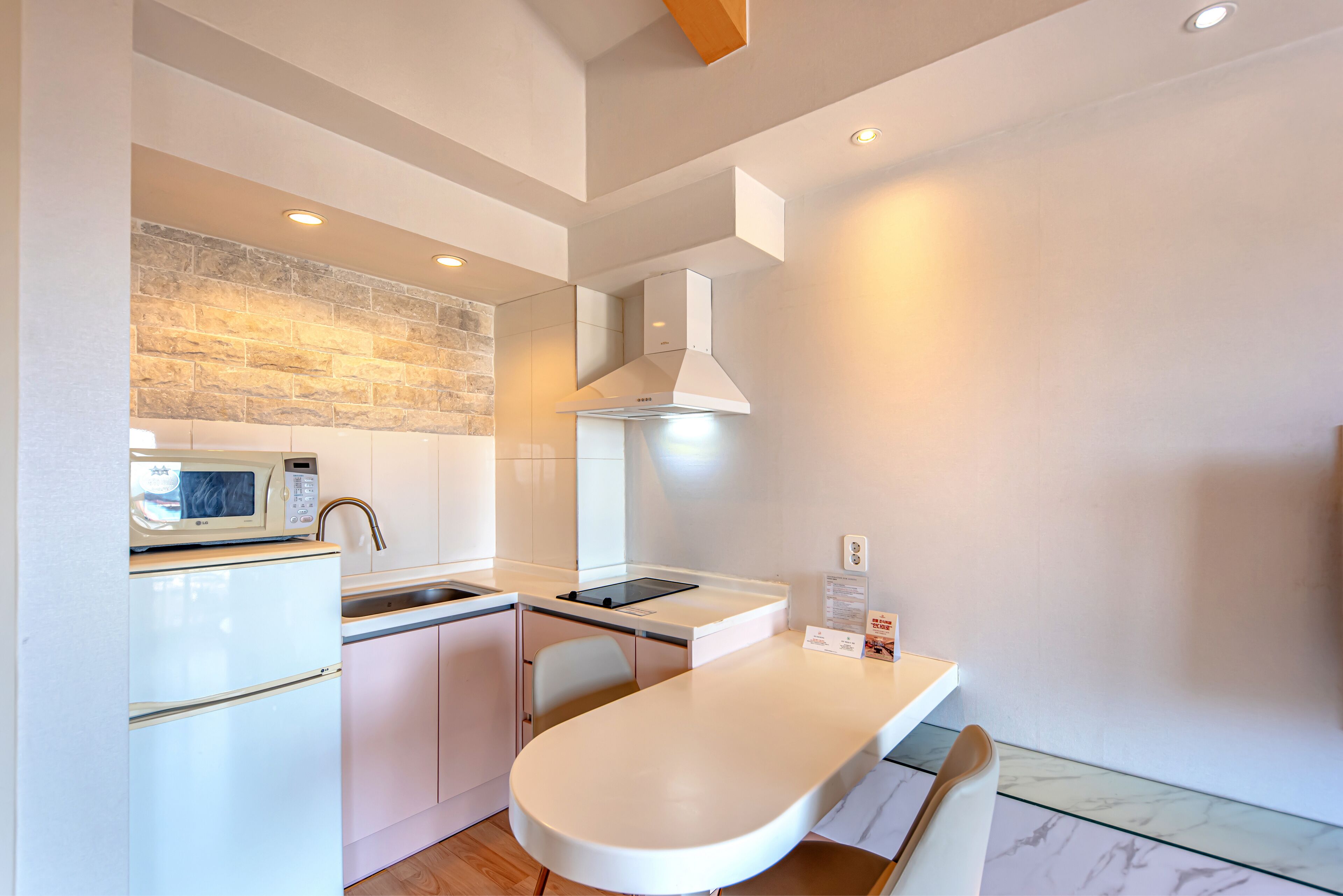 A modern kitchen with a microwave, sink, and white cabinets.