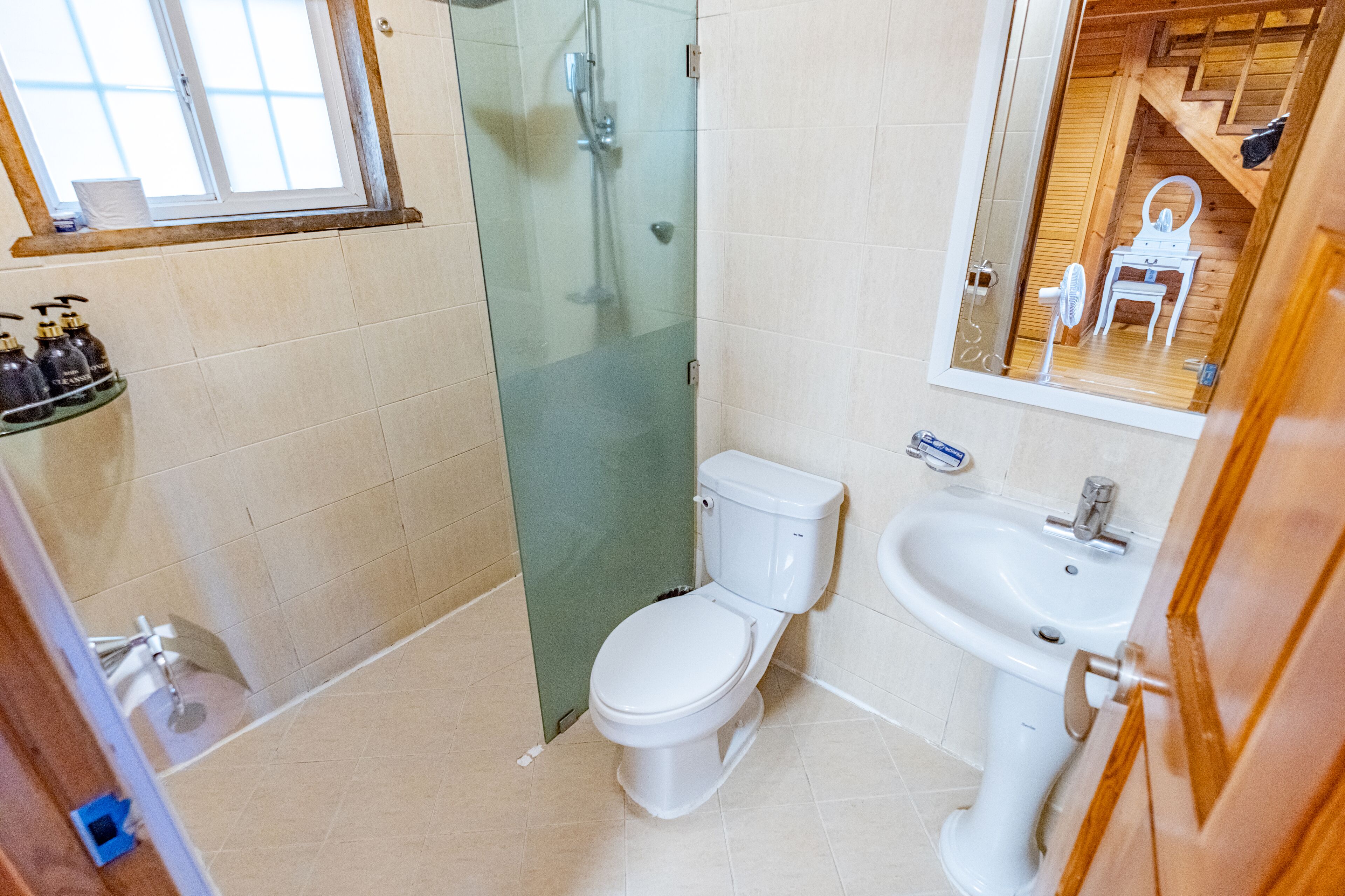 A bathroom with a glass-enclosed shower, a white toilet, and a sink.